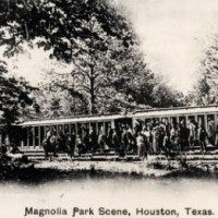 People disembark from rail cars among the trees in Magnolia Park